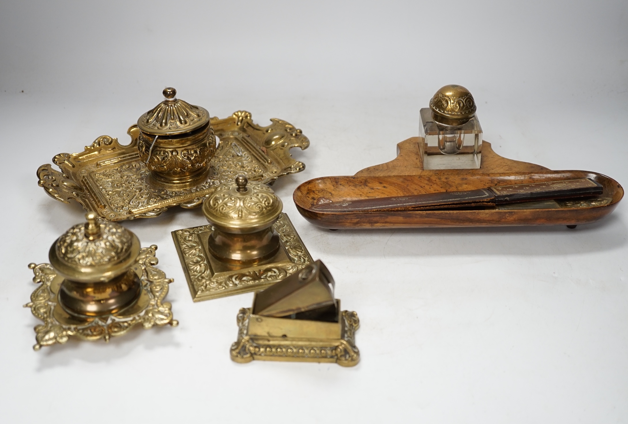 Sundry items to include brass desk stand, inkwells, letter openers and a cigar cutter, largest 26cm wide. Condition - fair